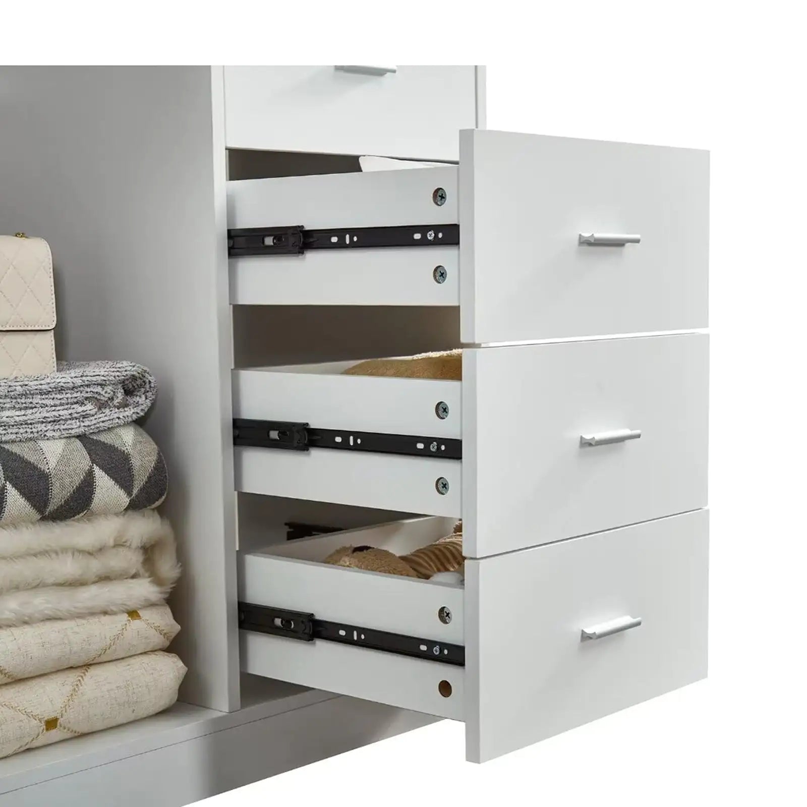 White closet organizer with hanging rod featuring three open drawers and folded clothes on the side