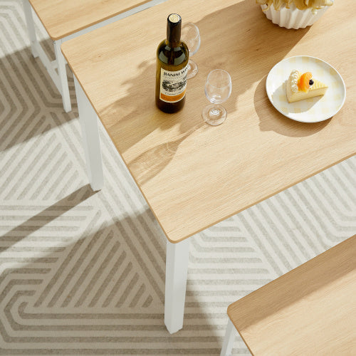 Light wood kitchen table counter with chairs featuring a wine bottle, glasses, and dessert plate