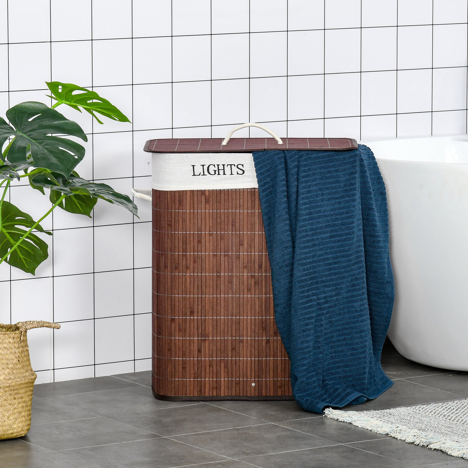 Shopi Vella collapsible laundry hamper with removable bags in brown with white label and blue towel beside bathtub