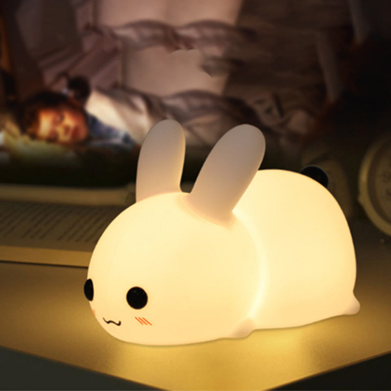 Colorful rabbit silicone night light glowing softly on a bedside table in a cozy room