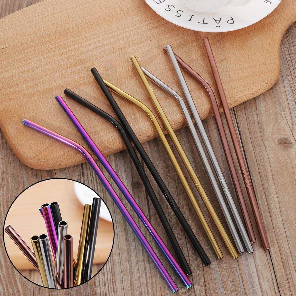 Colorful stainless steel straws in various metallic colors arranged on wooden surface by Shopi Vella