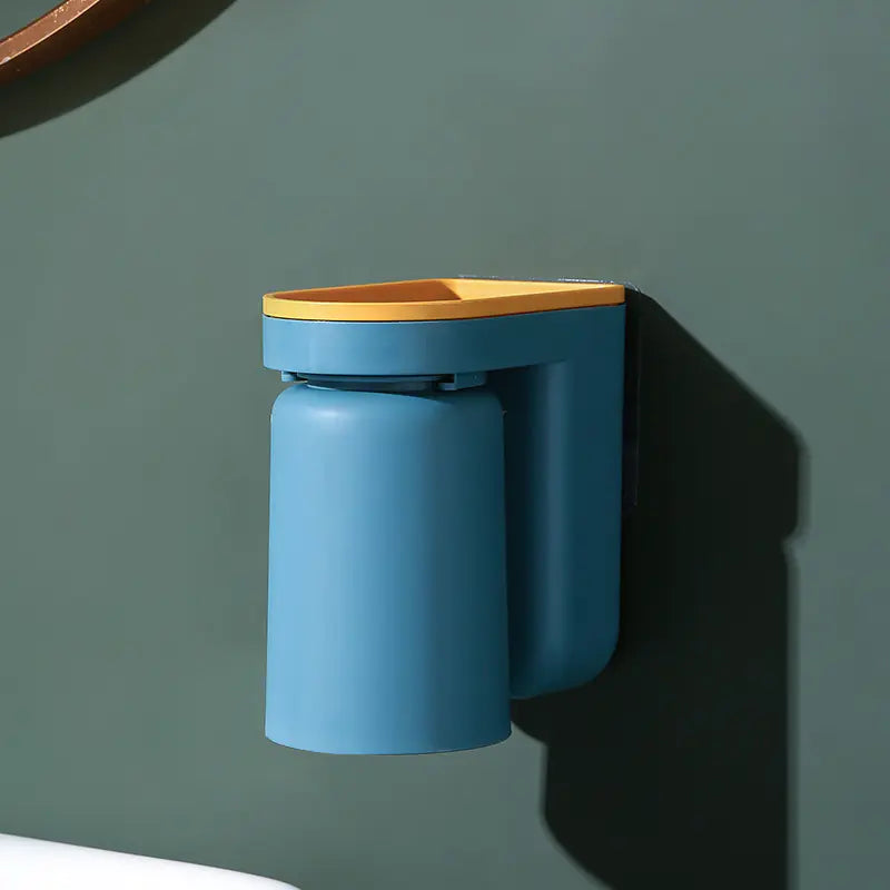 Blue and yellow wall-mounted toothbrush holder with cup attached on green bathroom wall