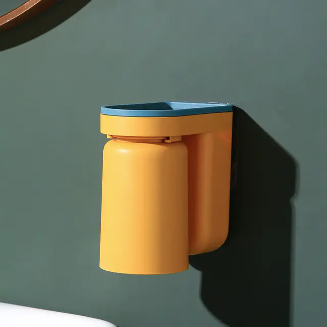 Modern yellow and blue wall-mounted toothbrush holder attached to a green bathroom wall