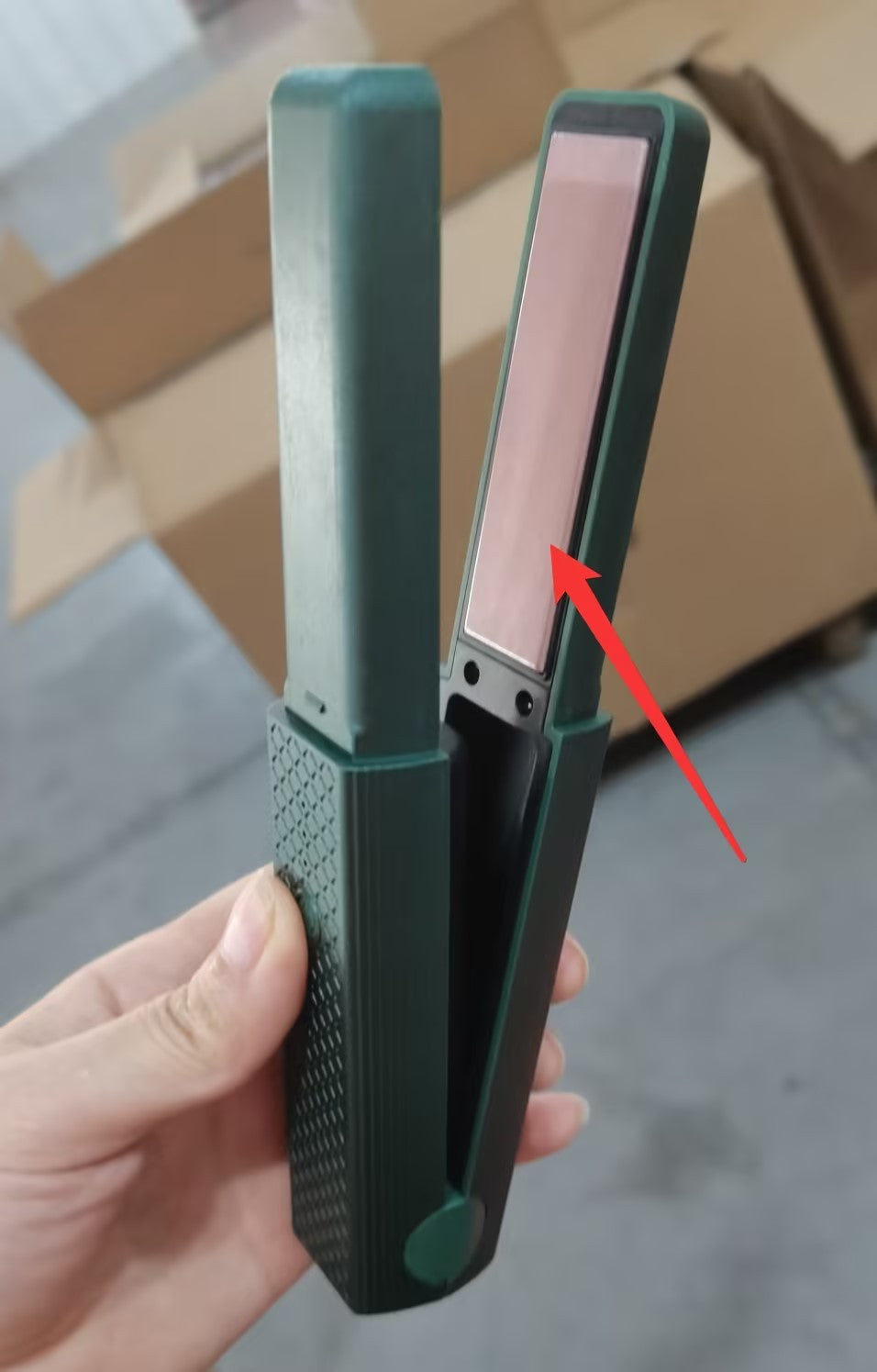 Cordless hair straightener for travel in green with sleek pink heating plates held in hand