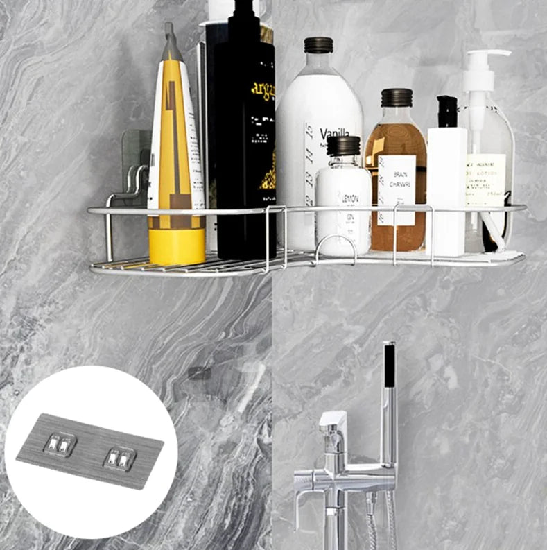 Stainless steel corner shower caddy shelf holding various shampoo and lotion bottles in bathroom