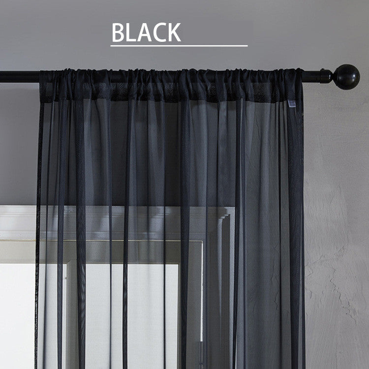 Black cotton linen window curtains hanging on a black curtain rod in a modern gray room