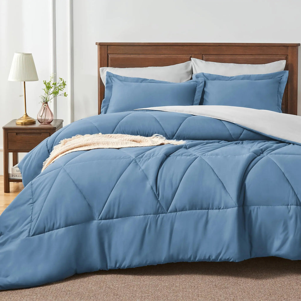 Cozy blue comforter set with sheets on bed in bedroom with wooden headboard and nightstand