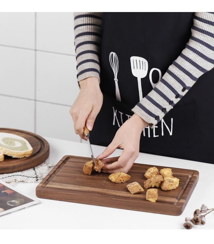 Person cutting cookies on a creative wood cutting board for kitchen by Shopi Vella