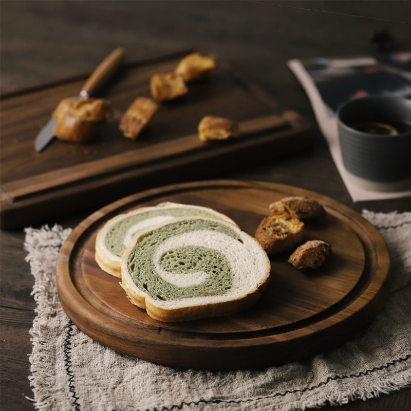 Creative wood cutting board for kitchen with sliced swirl bread and bread crumbs on rustic table