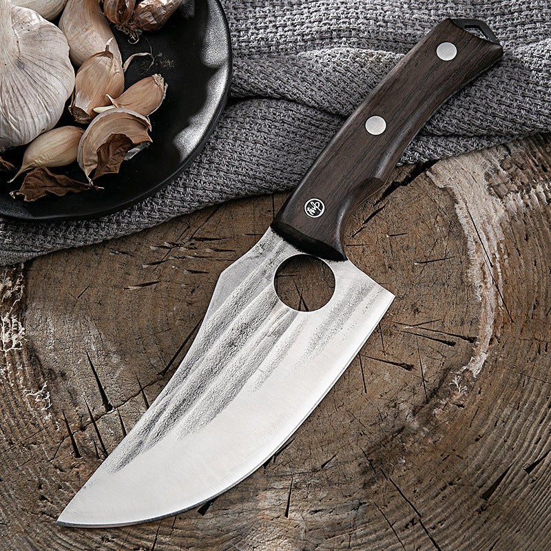 Shopi Vella kitchen deboning knife with wooden handle on rustic wooden surface near garlic cloves