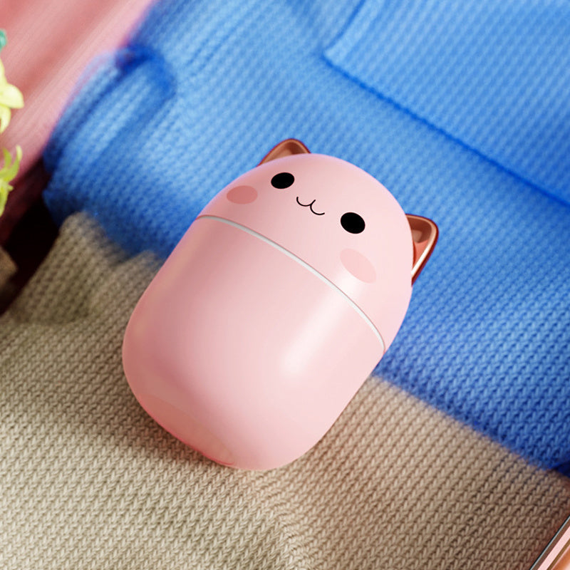 Shopi Vella cute cat air humidifier in pink with adorable face and ears on knitted fabric