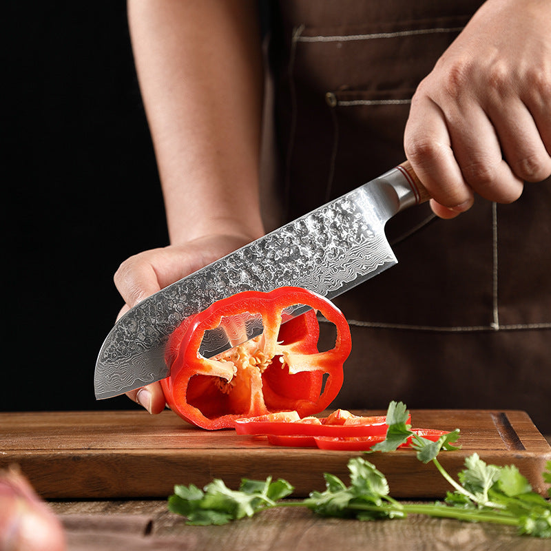 Shopi Vella Damascus steel kitchen knife slicing red bell pepper on wooden cutting board