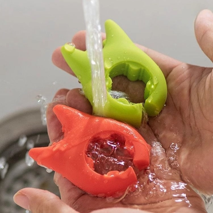 Shopi Vella multifunctional cooking spoon clip in green and orange being washed under running water in hand