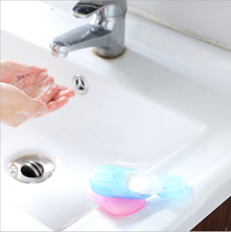 Disposable hand soap paper in blue and pink container beside sink for bathroom storage by Shopi Vella