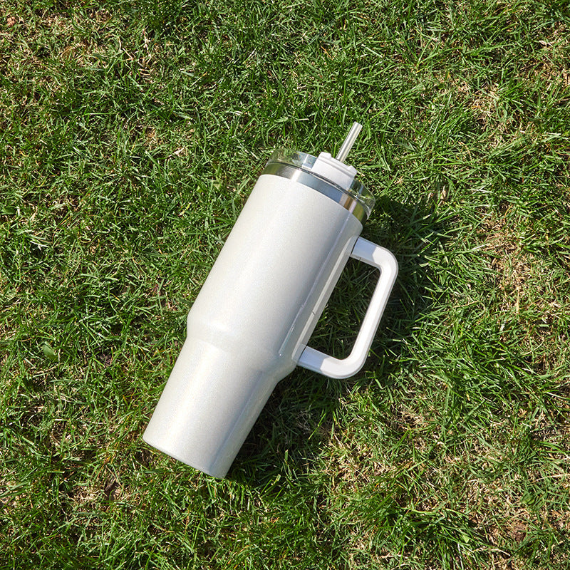 Shopi Vella white double-layer stainless steel cup with handle and straw on grass