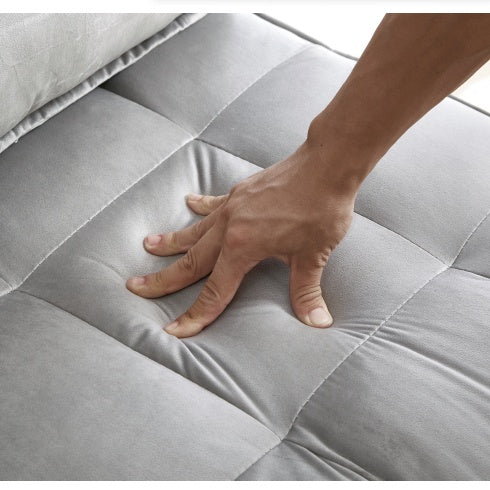 Hand pressing soft gray cushion of double seat sofa bed with detachable backs for comfort testing