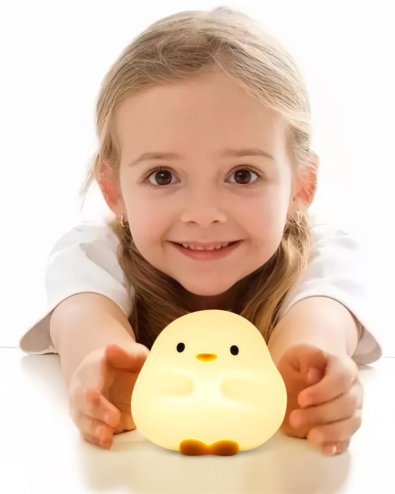 Young girl holding a glowing cartoon LED sleeping light shaped like a cute chick
