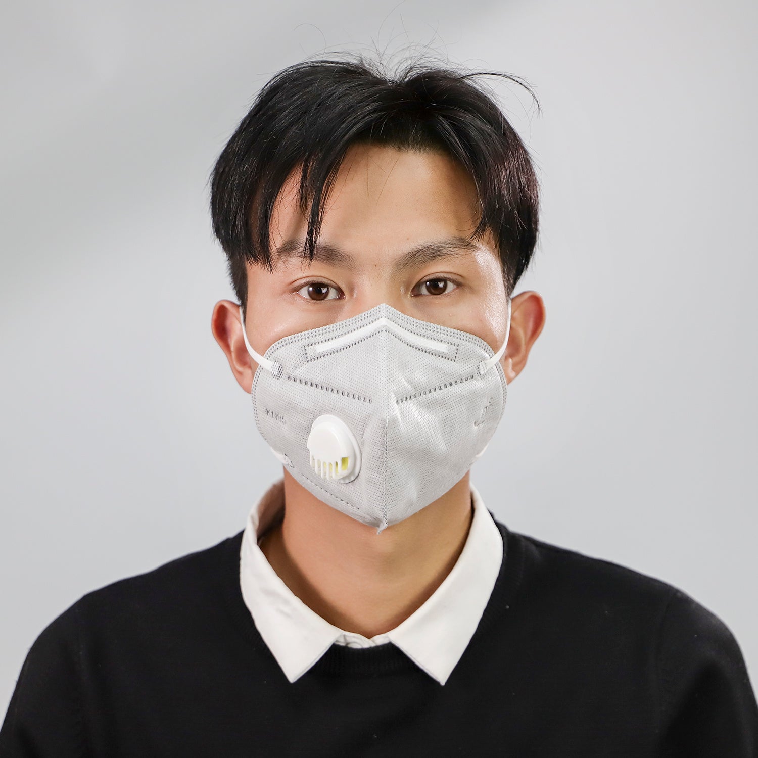 Man wearing a dustproof industrial protective mask with a white valve for safety and air filtration
