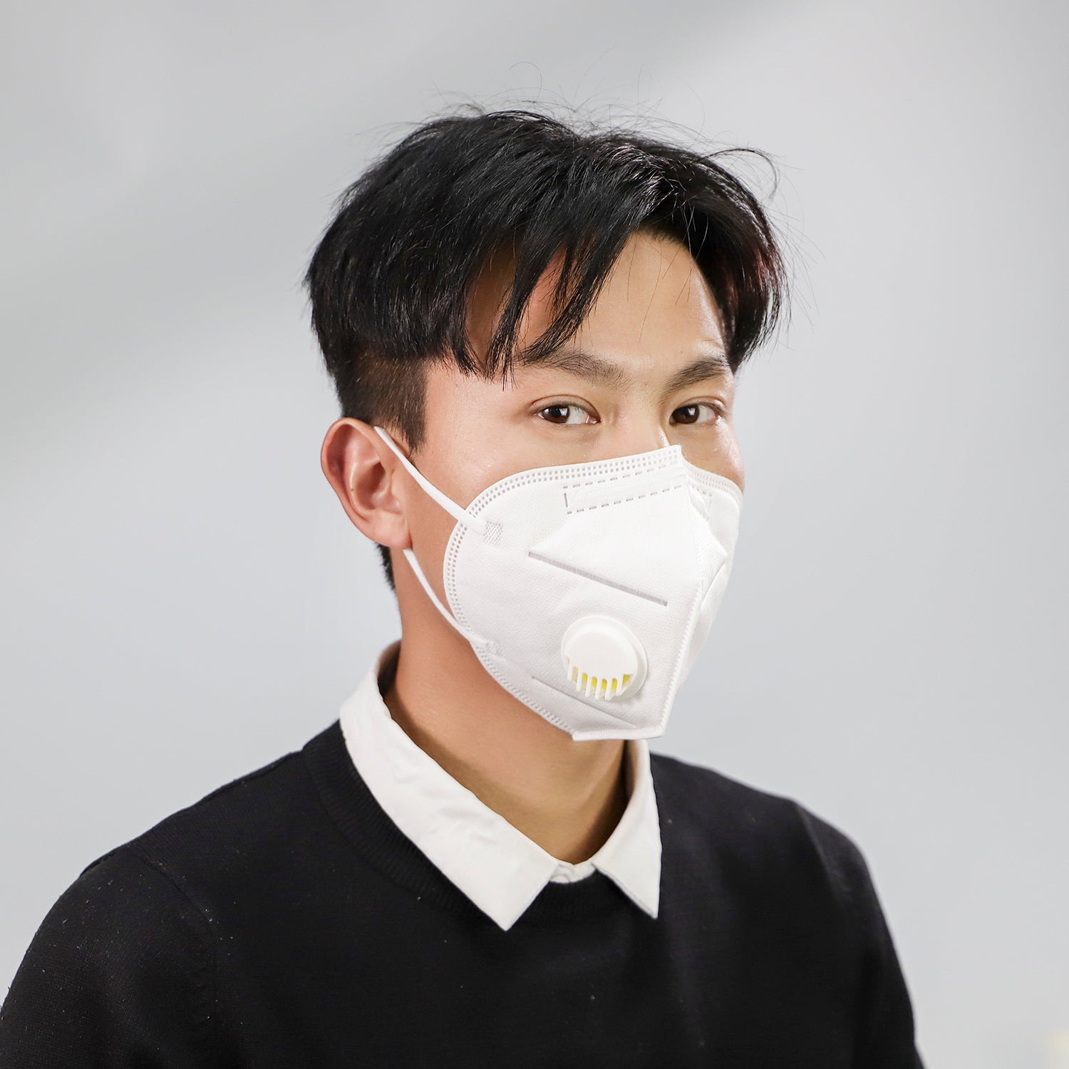 Man wearing a white dustproof industrial protective mask with valve for home storage use