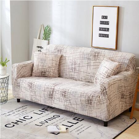 Beige and brown patterned elastic sofa cover on a three-seat couch with matching pillows in a modern living room