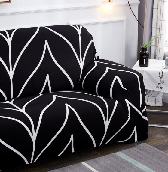 Black and white elastic sofa cover with modern geometric pattern on a two-seater couch