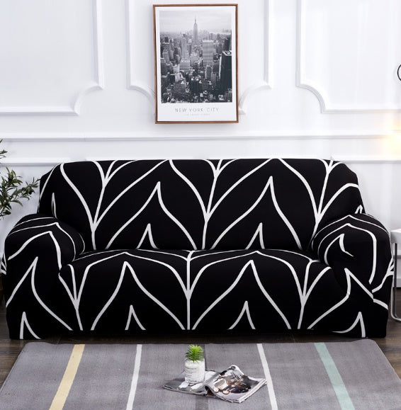 Black and white elastic sofa cover with modern abstract pattern on a three-seat sofa in a living room