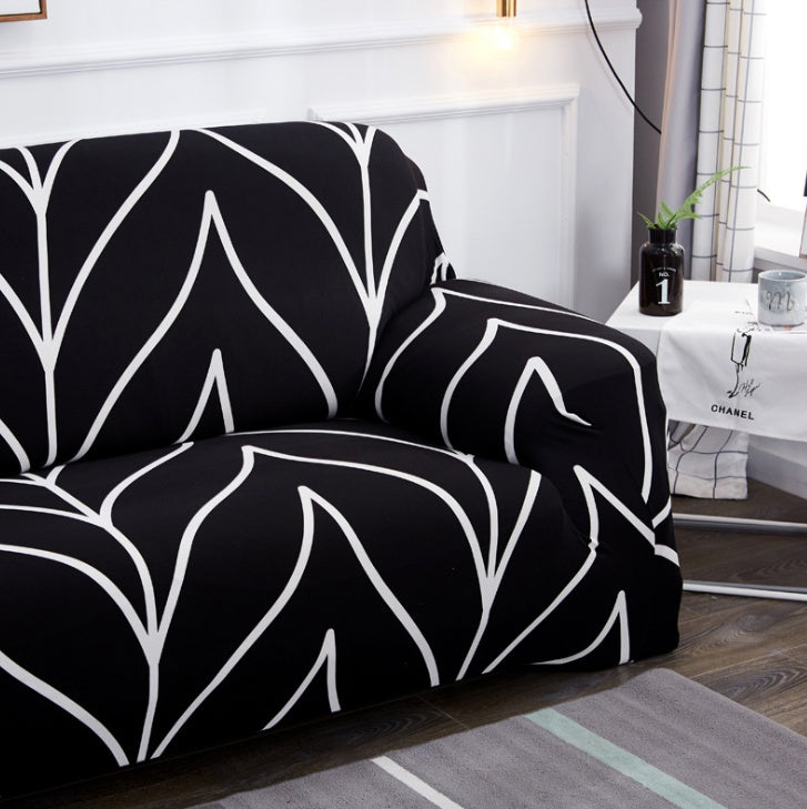 Black and white elastic sofa cover with modern leaf pattern on a two-seater sofa in living room