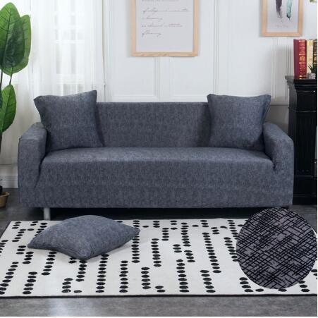 Gray elastic sofa cover fitted on a modern couch with matching cushions in a bright living room