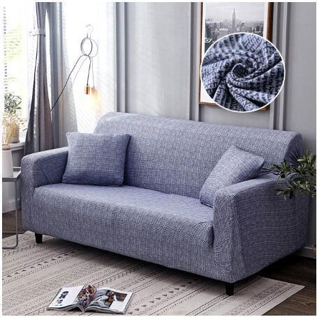 Gray elastic sofa cover on modern sofa with matching cushions in stylish living room setting