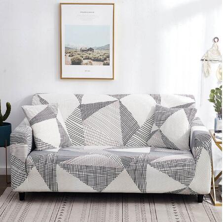 Geometric patterned elastic sofa cover fitted on white three-seater sofa with matching pillows