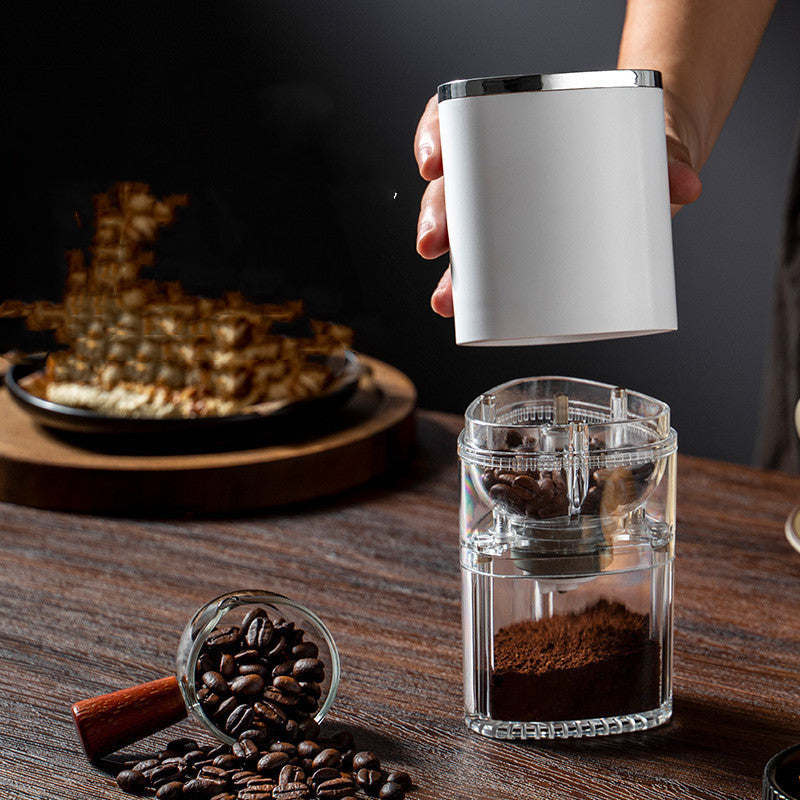 Shopi Vella electric coffee grinder portable with clear storage jar filled with ground coffee and coffee beans on wooden table