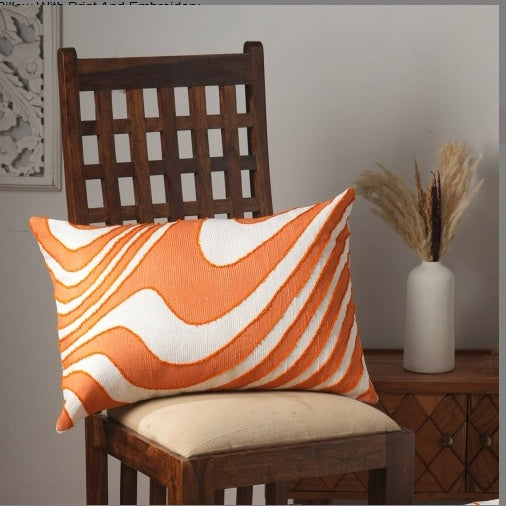 Orange and white embroidered throw pillow for living room on wooden chair with beige seat