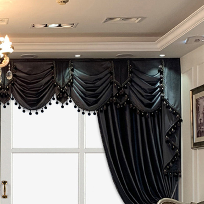 Shopi Vella european style black velvet drapes with elegant swag valance and pom pom trim in a luxurious living room