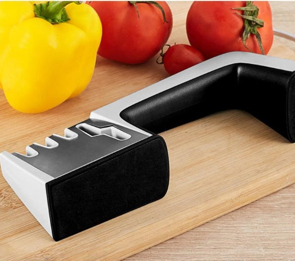Shopi Vella fast knife sharpener with ergonomic handle on wooden cutting board with vegetables