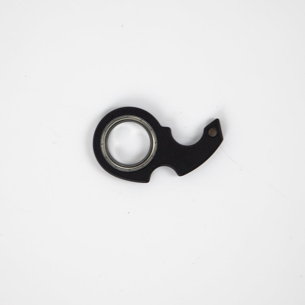 Shopi Vella black finger spinner bottle opener with metal bearing on white background