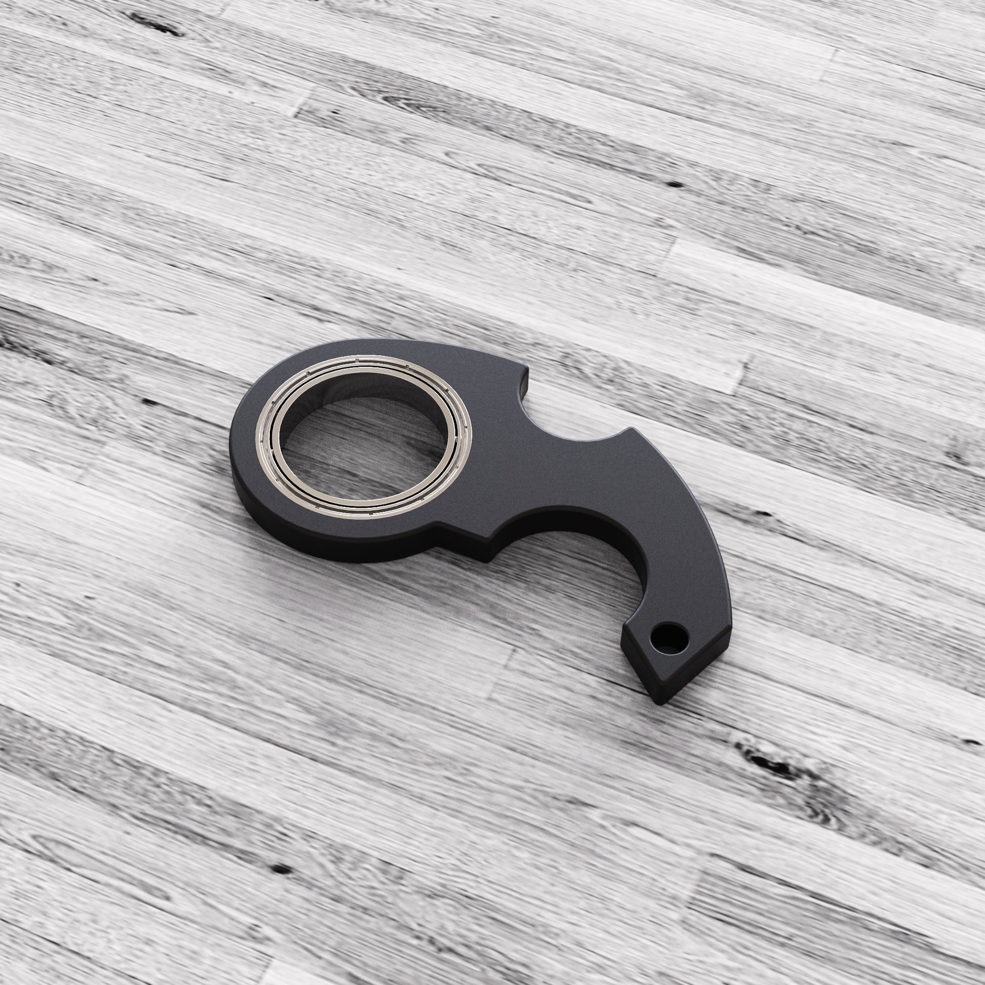 Shopi Vella black finger spinner bottle opener with metal bearings on wooden surface