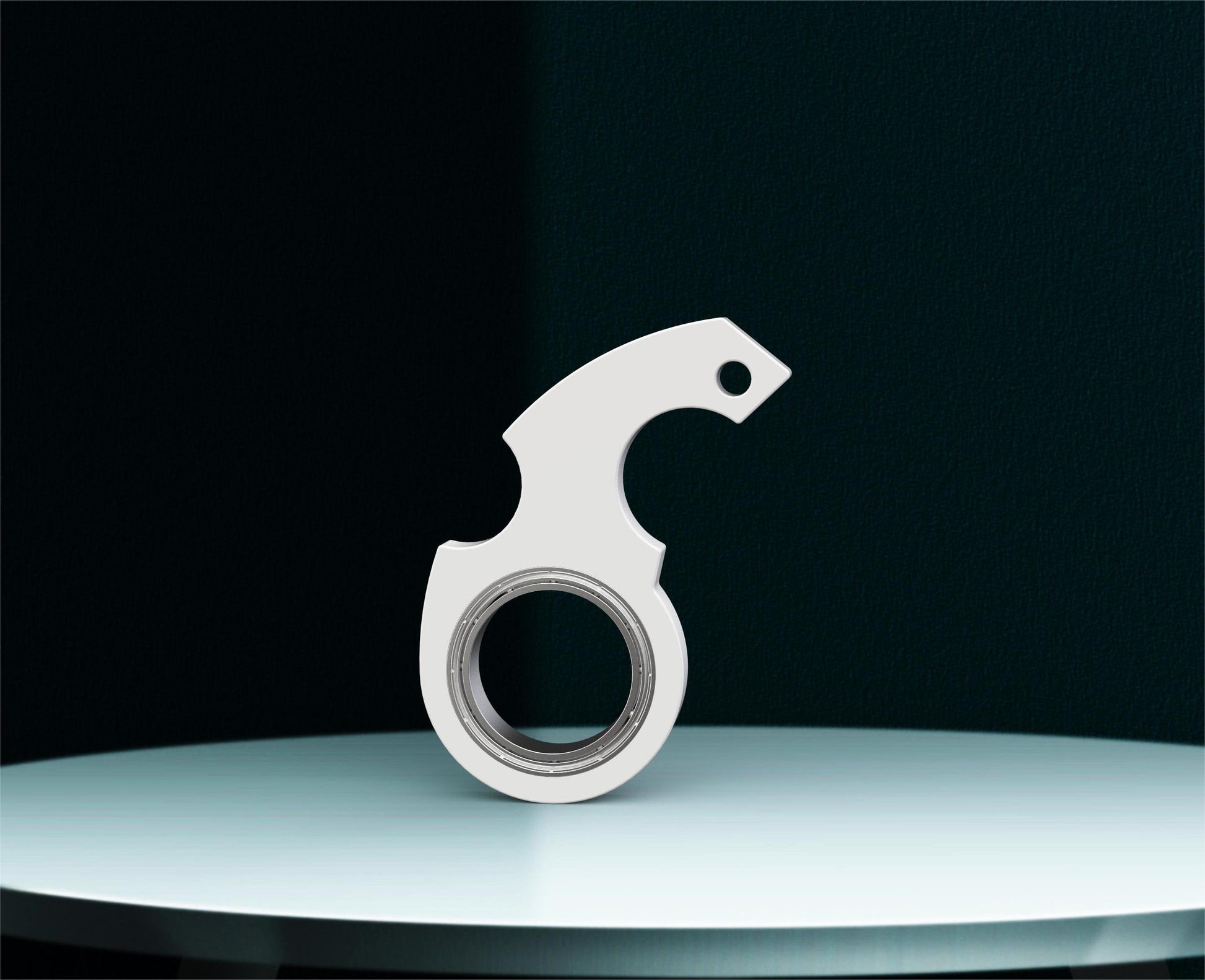 Shopi Vella finger spinner bottle opener in silver metal design placed on a white round surface