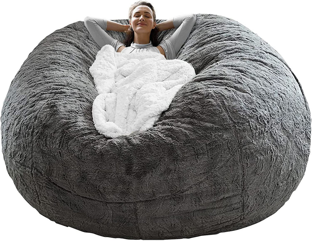 Fluffy velvet sofa bed cover in gray with a soft white blanket and relaxing woman lying on it