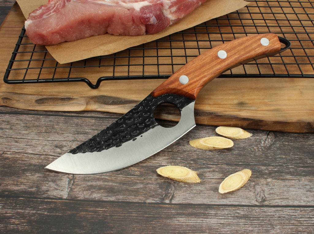 Shopi Vella forged boning knife with hammered blade and wooden handle on wooden surface