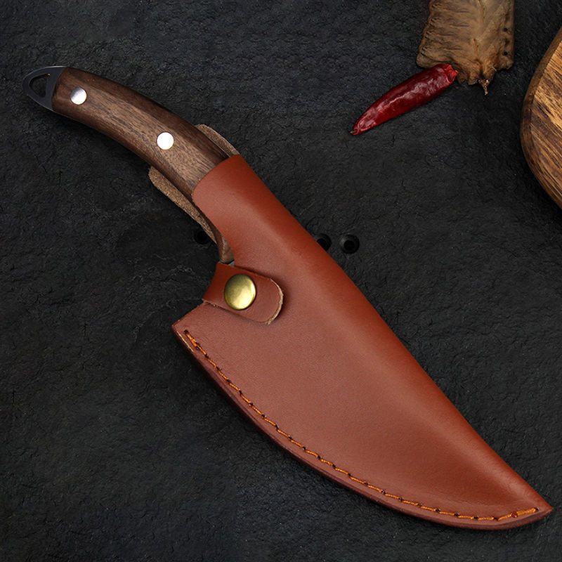 Shopi Vella forged boning knife with wooden handle in a brown leather sheath on a dark background