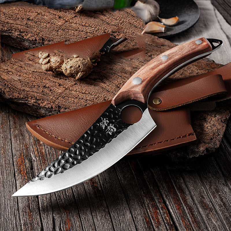 Shopi Vella forged boning knife with hammered blade and wooden handle on wooden surface with leather sheath