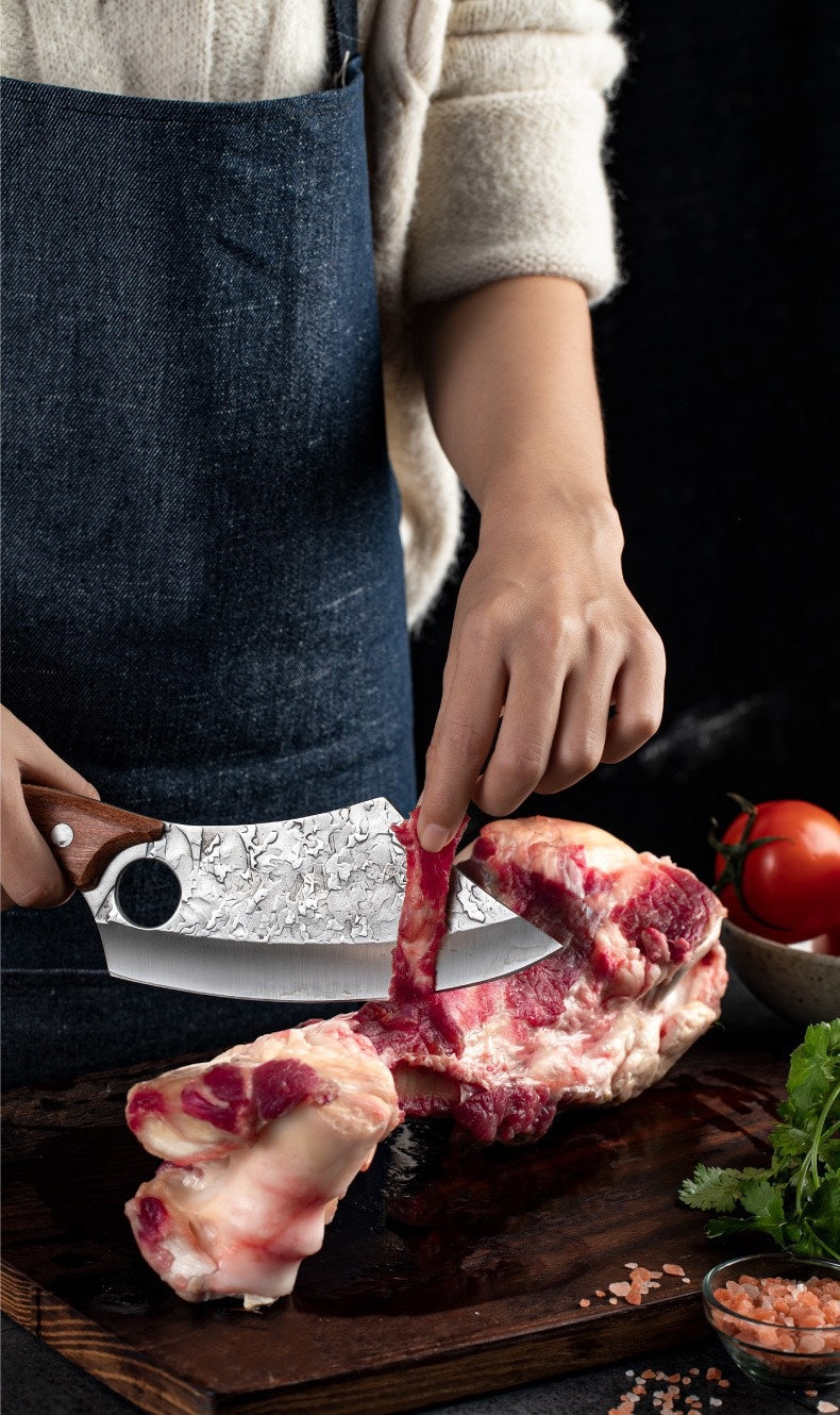 Shopi Vella forged small kitchen knife cutting raw meat on wooden board with herbs and tomatoes