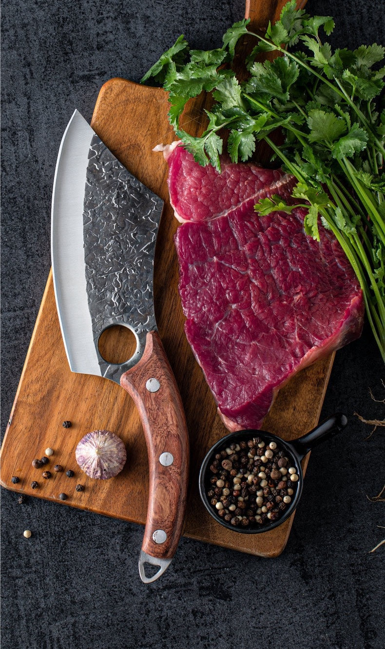 Shopi Vella forged small kitchen knife with wooden handle next to raw steak and herbs on cutting board