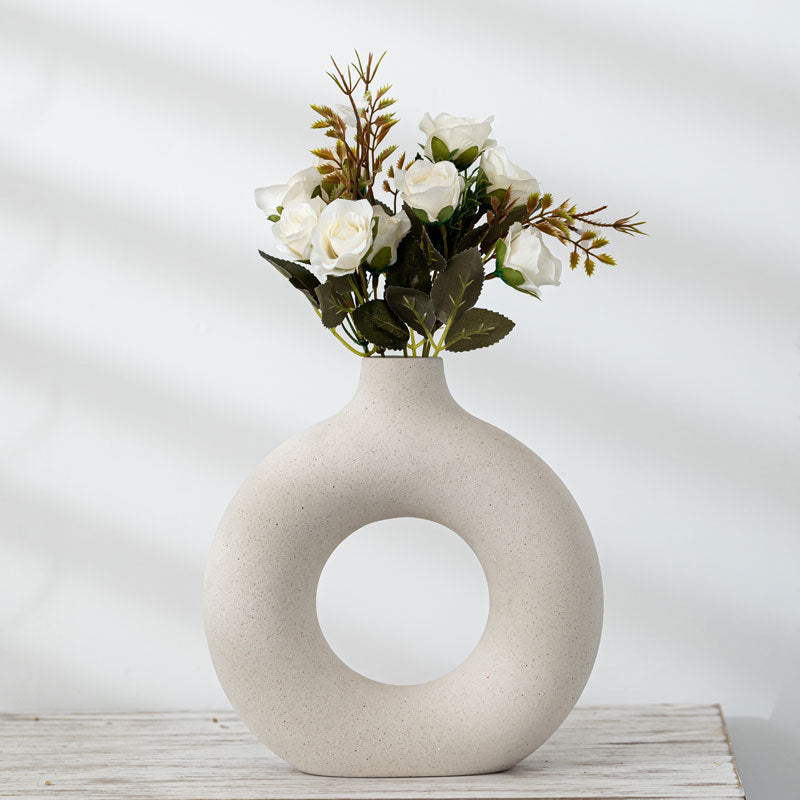 Shopi Vella frosted particle flower arranging vase with white roses and green foliage on wooden surface