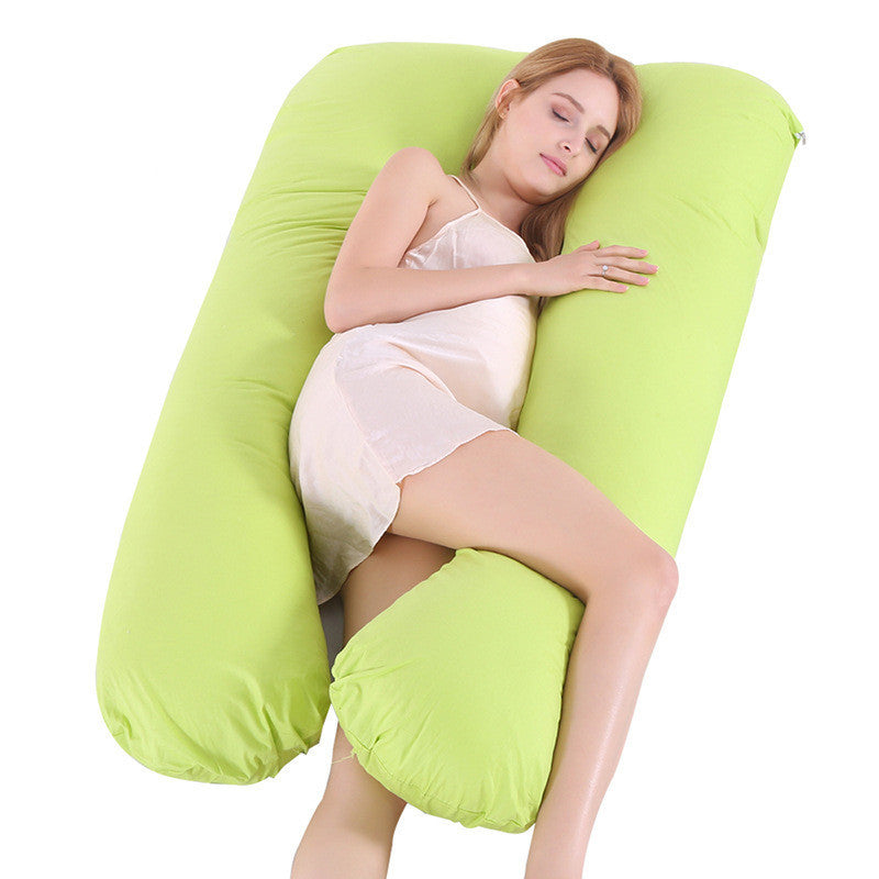 Woman sleeping comfortably on a green full body maternity pillow with matching pillow case