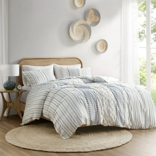 Full queen duvet cover with chenille in blue and white stripes on bed with wooden headboard and round rug