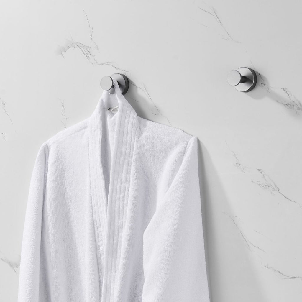 Shopi Vella furniture hardware coat hooks with screws holding a white bathrobe on marble wall