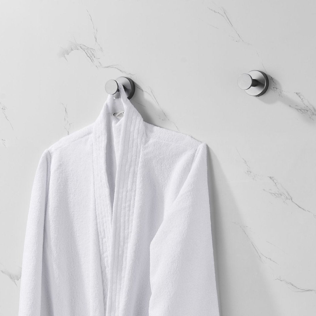 Shopi Vella furniture hardware coat hooks with screws holding a white bathrobe on marble wall