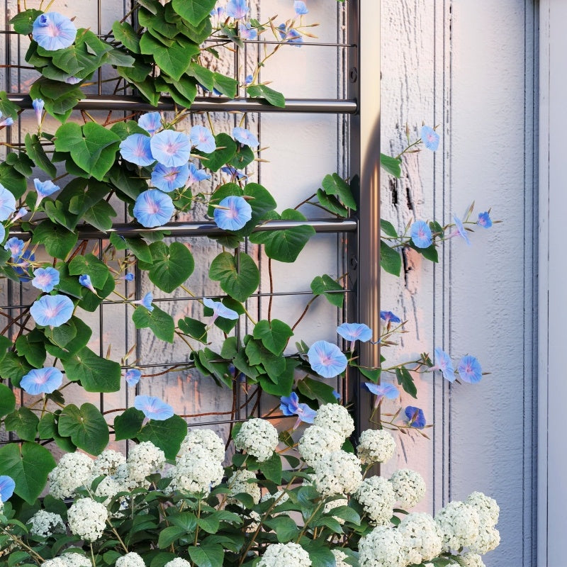 Shopi Vella galvanized raised garden bed with blooming white and blue flowers against a light wall