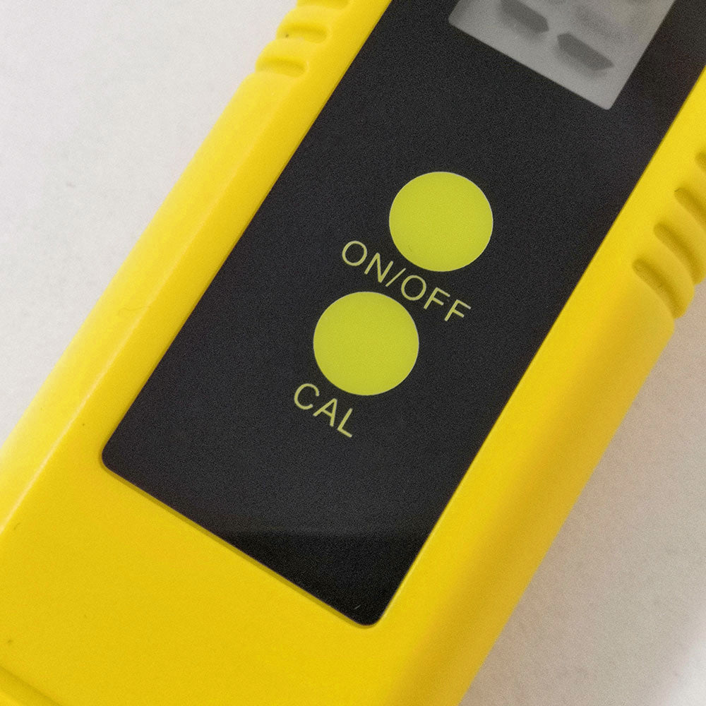 Close-up of yellow digital pH meter for aquarium showing on/off and calibration buttons